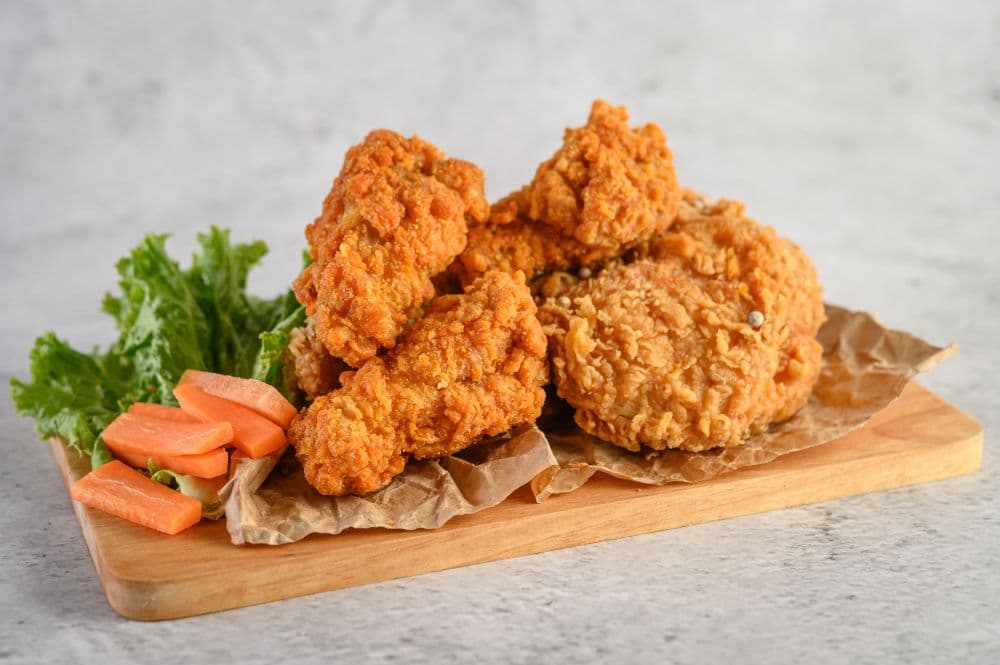 photologuephotos2023-08pollo-frito-crujiente-sobre-tabla-cortar-maderajpg