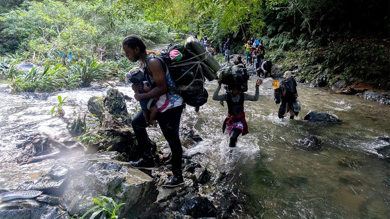 Una familia de migrantes por la selva colombiana en el Tapón del Darién.