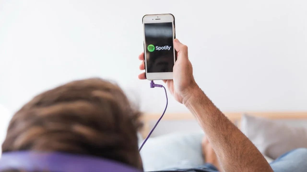 photologuephotos2024-03young-man-holding-smartphone-with-spotify-appjpg photologuephotos2024-03young-man-holding-smartphone-with-spotify-appjpg