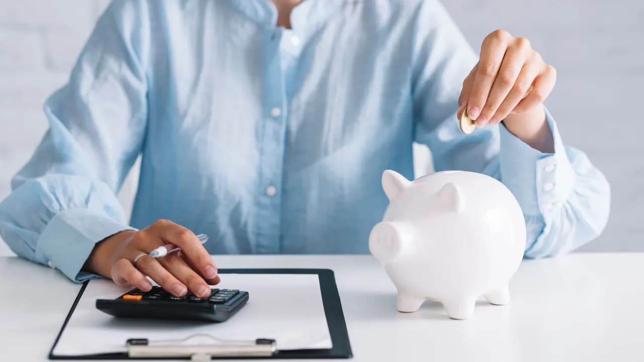 photologuephotos2022-11businesswoman-using-calculator-while-inserting-coin-in-piggybank-at-workplacejpg photologuephotos2022-11businesswoman-using-calculator-while-inserting-coin-in-piggybank-at-workplacejpg