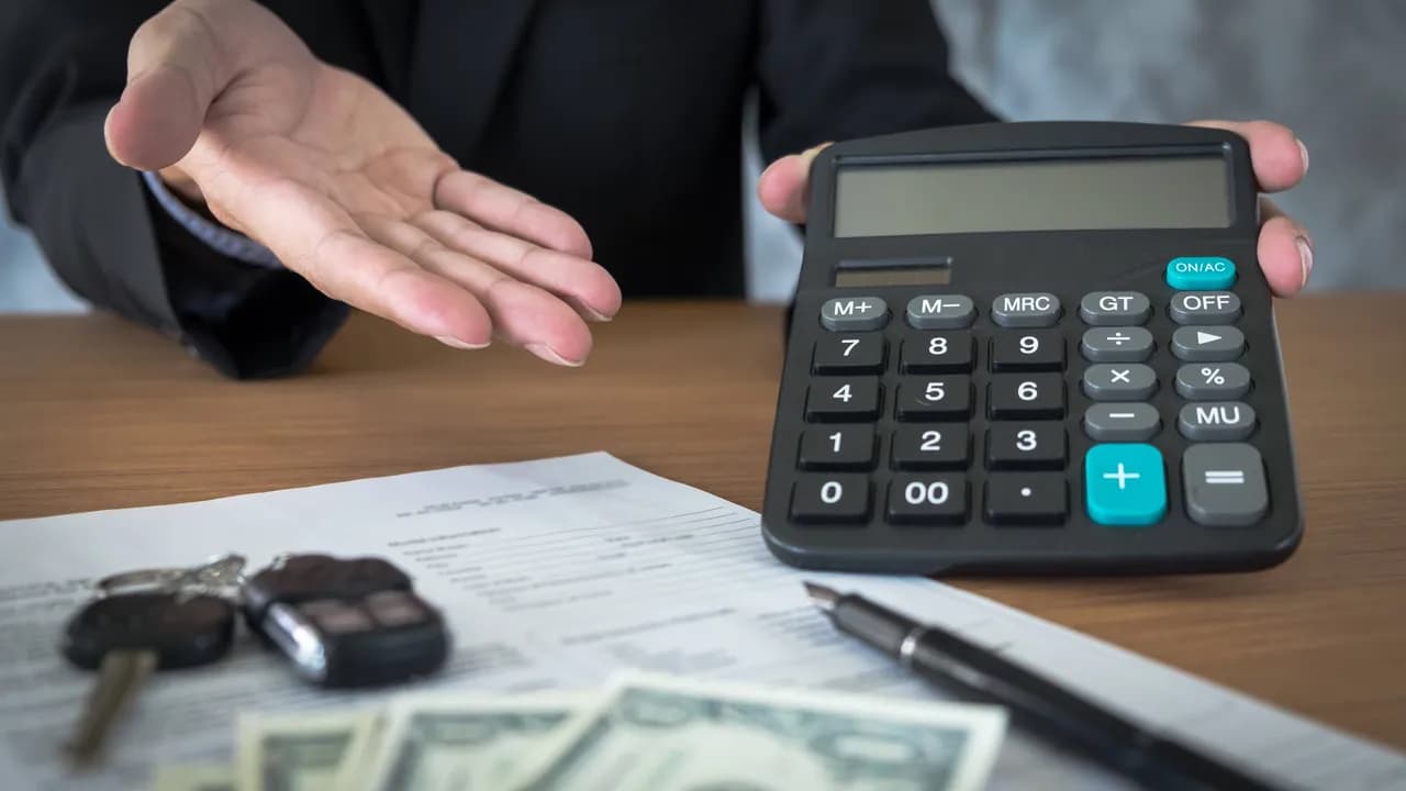 photologuephotos2025-01car-salesman-holding-key-calculating-price-dealership-office_1jpg photologuephotos2025-01car-salesman-holding-key-calculating-price-dealership-office_1jpg