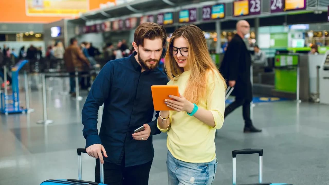 photologuephotos2022-10young-couple-is-standing-between-two-suitcases-in-airport-she-has-long-hair-glasses-sweater-jeans-he-wears-beard-black-shirt-with-pants-they-are-reading-on-tablet_1jpg photologuephotos2022-10young-couple-is-standing-between-two-suitcases-in-airport-she-has-long-hair-glasses-sweater-jeans-he-wears-beard-black-shirt-with-pants-they-are-reading-on-tablet_1jpg