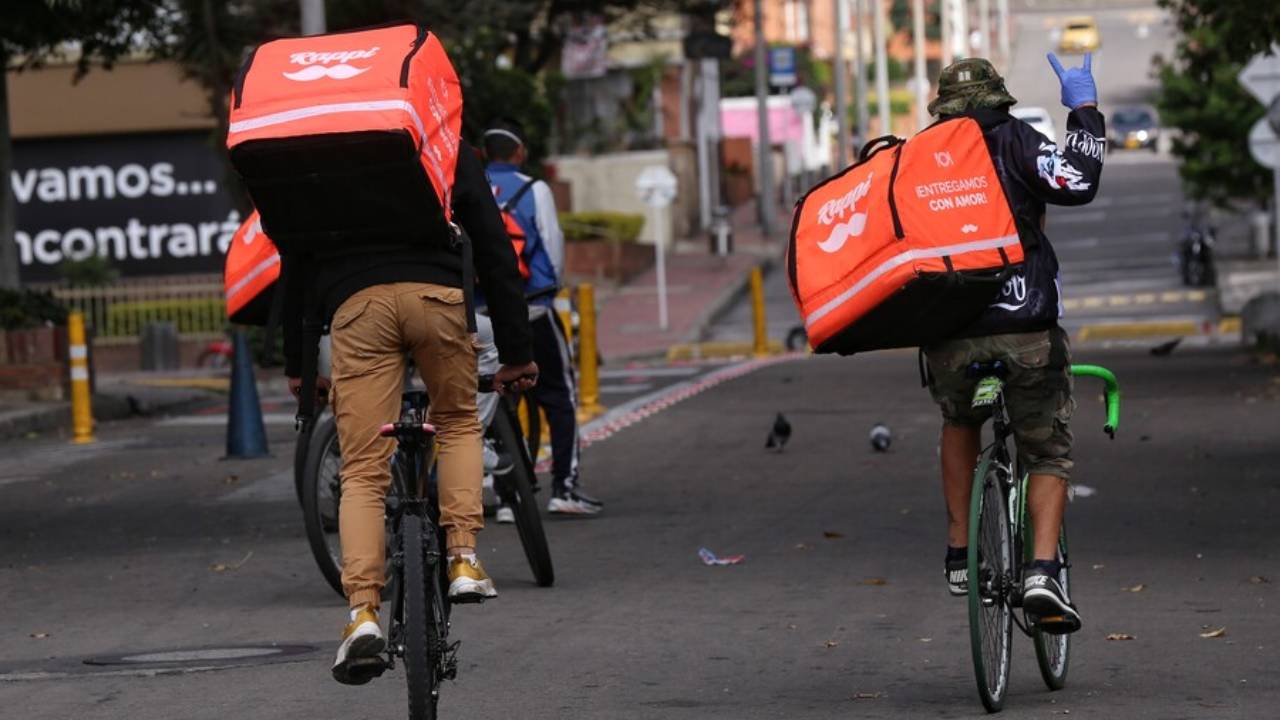 Repartidores de Rappi en bicicleta y moto circulan por las calles de Bogotá, representando la presencia urbana de la plataforma de última milla. Crédito: Colprensa.