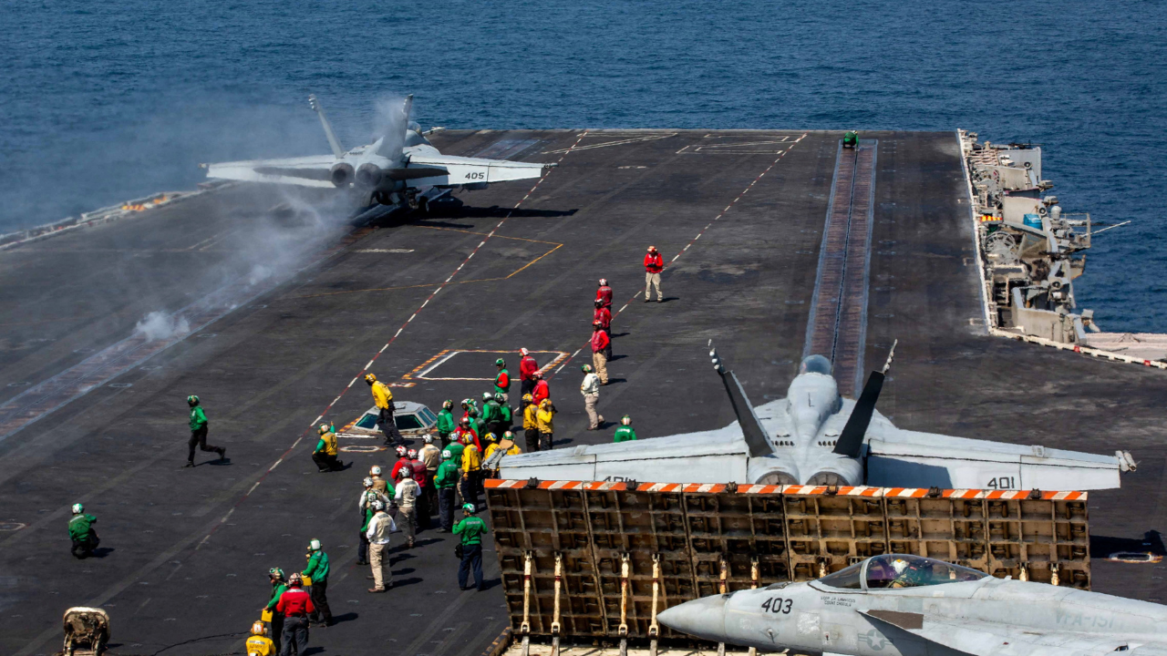 Un F/A-18E Super Hornet despega mientras otro se alista en la cubierta del portaaviones clase Nimitz USS Abraham Lincoln, en apoyo a la operación ‘Furia Épica’.